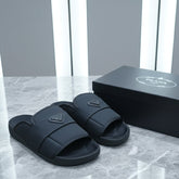 Black slides with a triangular logo on a marble surface next to their packaging box.
